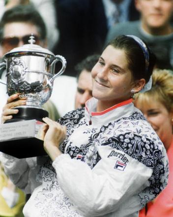 PARIS, FRANCE: Yugoslavian tennis player Monica Seles is all smiles as she holds up the winner's cup after defeating Germany's Steffi Graf in three sets (6-2, 3-6, 10-8) in the final of the French Open At Roland-Garros 06 June 1992. Seles is the first woman to win the Frenc Open for the third time consecutively. (Photo credit should read JEAN-LOUP GAUTREAU/AFP/Getty Images)